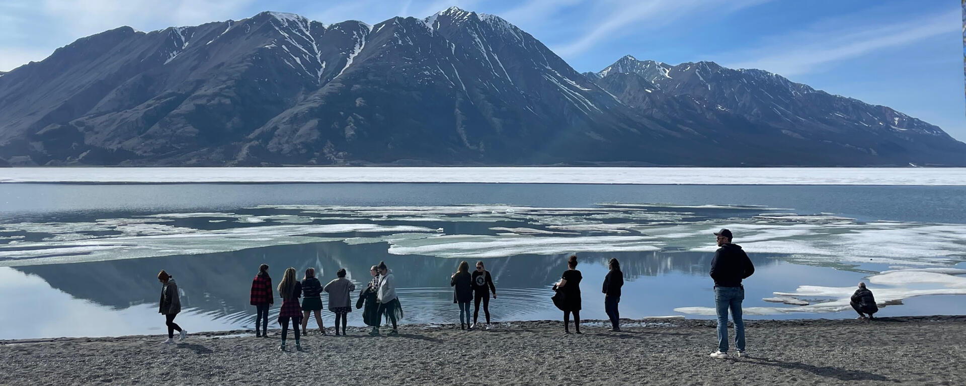 Students take in the view of the mountain and lake during the Yukon field course in May 2023
