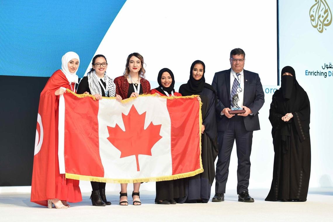 The UCalgary team accepts their silver award with a flag borrowed from the Canadian Embassy in Doha. From left: Hager Ben Mansour, Faculty of Science; Mais Abu Saleh, Faculty of Kinesiology; Rineem Saleh and Heyam Abdulrahman, Faculty of Arts; Machaille Al-Naimi, of the Qatar Foundation; Ziad Abusara, team coach from the Faculty of Kinesiology; and Hayat Abdullah Marafi, the executive director of QatarDebate. Photos courtesy Ziad Abusara