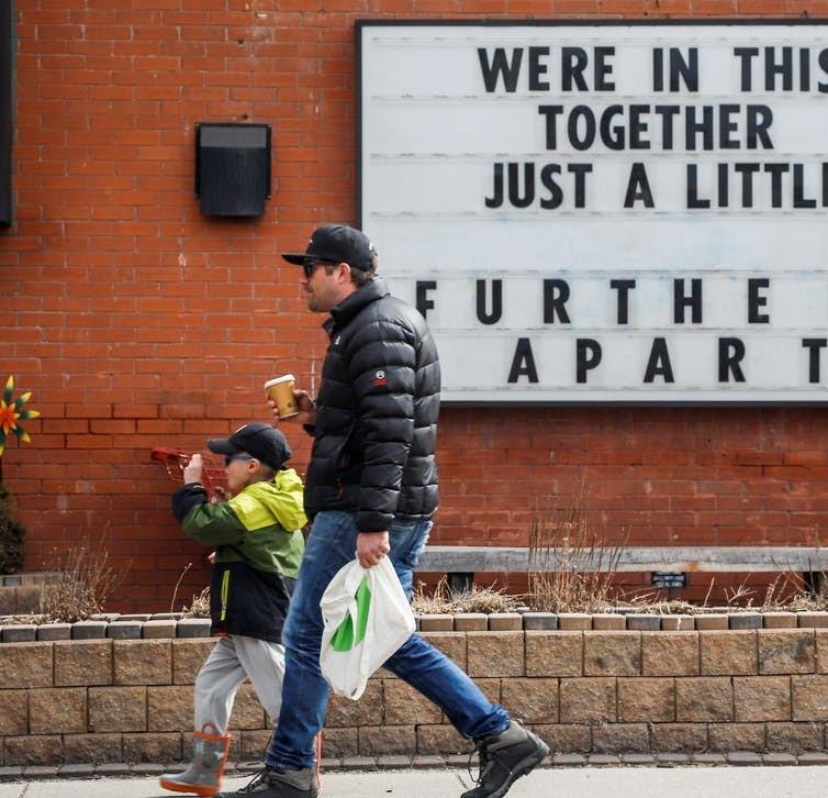 A child and adult walk outside in Calgary, in April 2020 during the COVID-19 pandemic. 