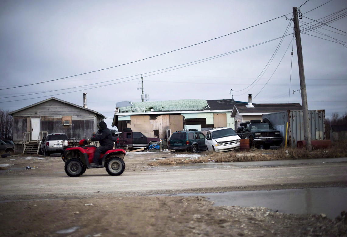 A man rides his ATV in the northern Ontario First Nations community of Attawapiskat, in April, 2016.