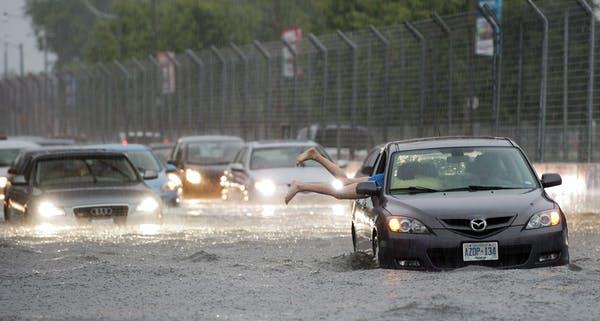 A woman gets back into her flooded car on Lakeshore Boulevard, Toronto 