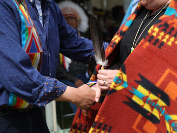 Eagle feathers are presented to Indigenous students receiving doctoral degrees
