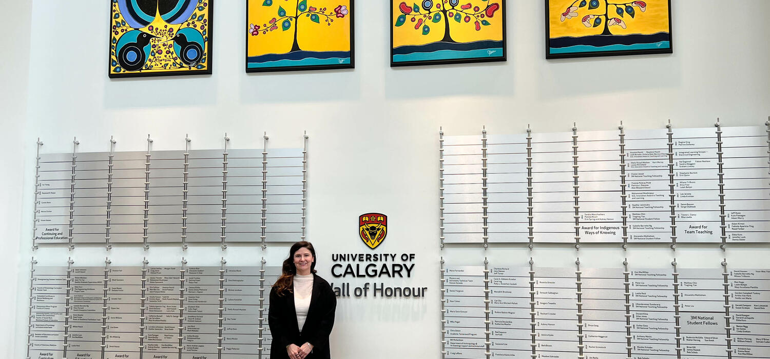 Dr. Jennifer Leason stands in front of her artworks on the Wall of Honour in the Taylor Institute