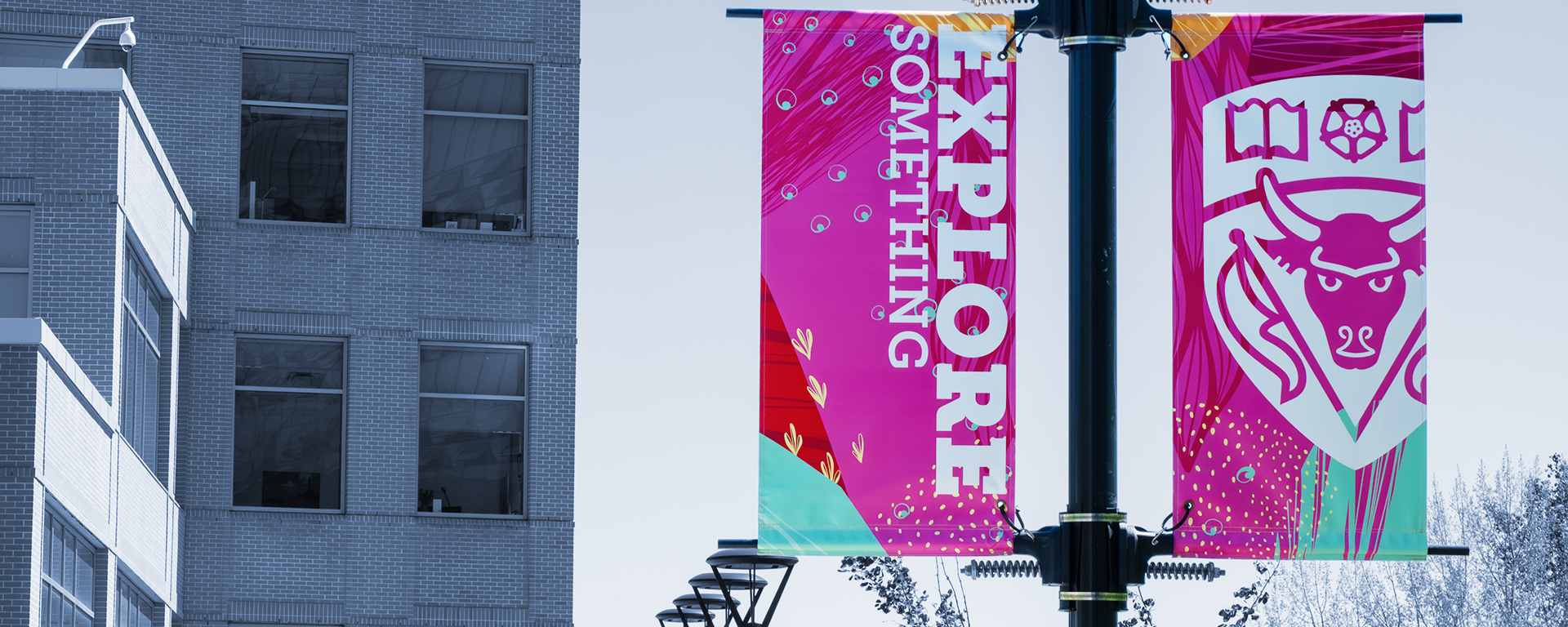 Explore Something banner in full colour against a cyanotype background of campus buildings