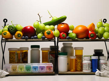 Image of fruits and vegetable on shelf above another shelf with medications