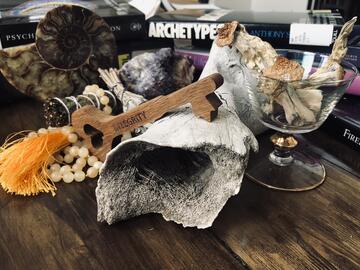 Photo of wood key over driftwood and a glass with mushrooms in it