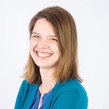 white woman with brown hair and teal cardigan