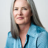 I am a white woman with long, straight grey hair.  I am wearing a little blue shirt 