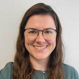 Headshot of Dr. Brittany Edgett from the shoulders up smiling in a green business casual top.