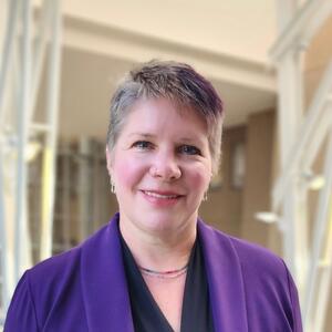 Smiling woman with short hair in a purple jacket