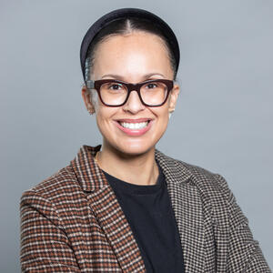 Supervisor photo - mid-30s woman with tan skintone, glasses, and blazer